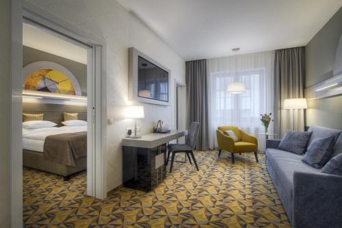 a hotel room with a bed and a desk and a couch at Hotel Essence in Prague