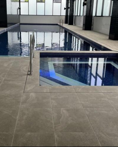 a swimming pool with a chair in a building at Comfort Living - 3 Bedroom sleeps 6 , parking, pool, other amenities - Near Showgrounds, NO PARTIES in Sydney