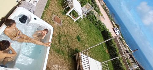 a man and a woman in a swimming pool at Cluxury-Torre dei Saraceni BOUTIQUE APT BY THE SEA Beach, Pool,Private Jacuzzi, Parking in Cervo