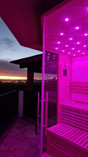 a purple room with benches on a roof with the sunset at Villa Le Agavi & Spa in Scarlino