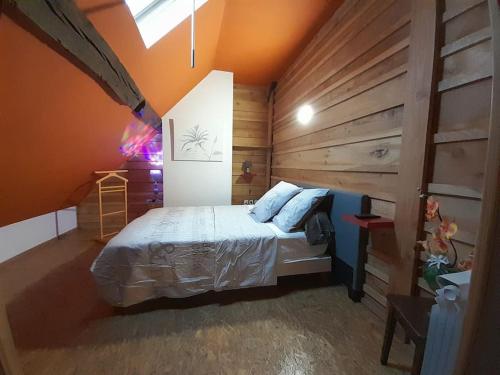 a bedroom with a bed and a wooden wall at La cabane: Chambre double, salle de bain privée in Vatan