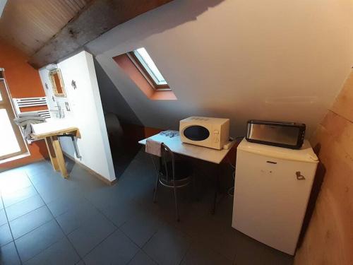 a small room with a desk with a microwave on it at La cabane: Chambre double, salle de bain privée in Vatan