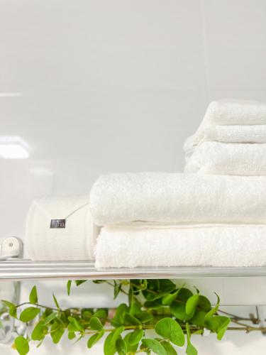 a pile of towels on a shelf with a plant at Tuna Hotel Phú Yên in Liên Trì (3)