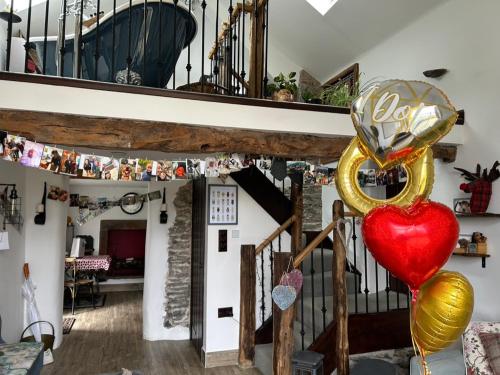 a living room with a staircase and a heart balloon at Rosie's Barn in Penrith