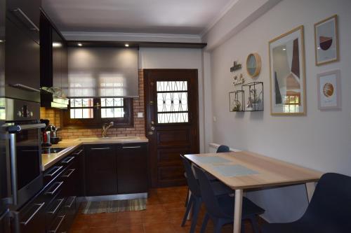 a kitchen with a wooden table and a dining room at Ampelos Hillside Villa in Akrata