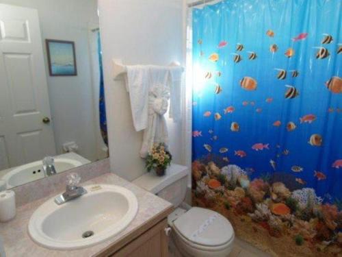 a bathroom with an aquarium shower curtain with a toilet and sink at Turkey Oak Villa IR021 in Kissimmee