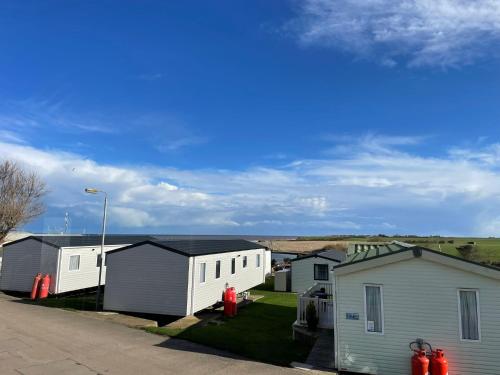 a row of white houses with a street at Little Owl - Holiday Home - Caravan Break in Tunstall