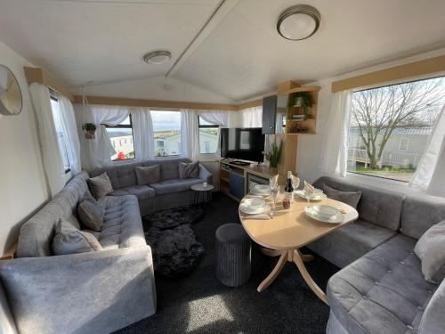a living room with a couch and a table at Little Owl - Holiday Home - Caravan Break in Tunstall