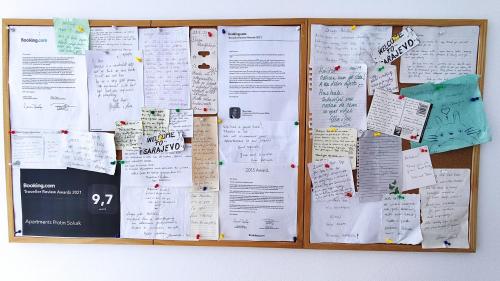 a bulletin board with many papers on it at Apartments Protin sokak in Sarajevo