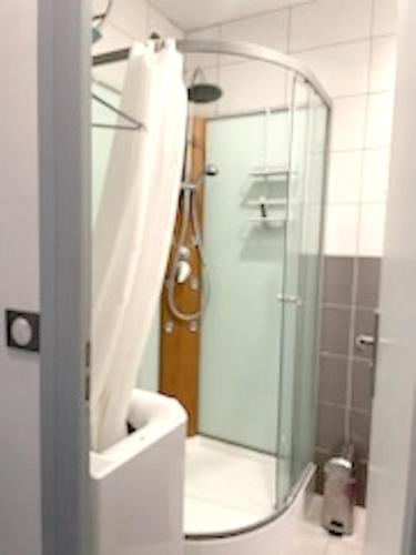 une salle de bain avec une douche avec une porte vitrée dans l'établissement Charmant appartement à La Baule 67 m² vue jardin et mer, à La Baule