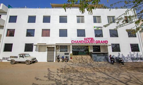 een wit gebouw met motoren ervoor geparkeerd bij Treebo Trend Chandigarh Grand in Chandīgarh