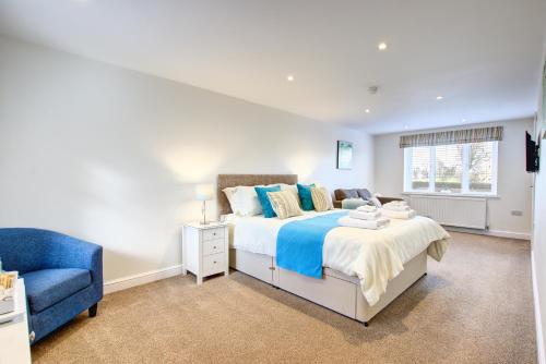 a bedroom with a bed and a blue chair at Rooms At Aysgarth ,Town Ends in Aysgarth