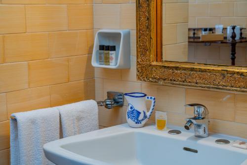 bagno con lavandino bianco e specchio di Villa Arrecifes a Fertilia