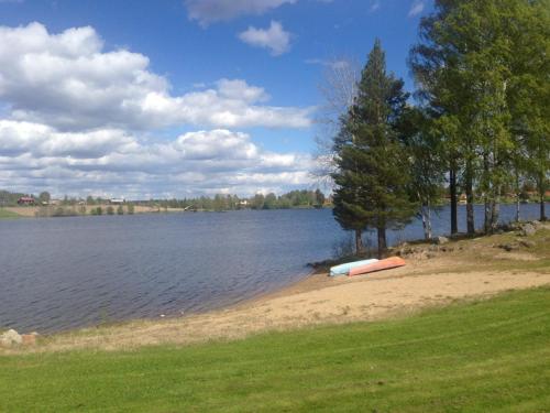 a boat sitting on the shore of a lake at Delsbo Camping in Delsbo