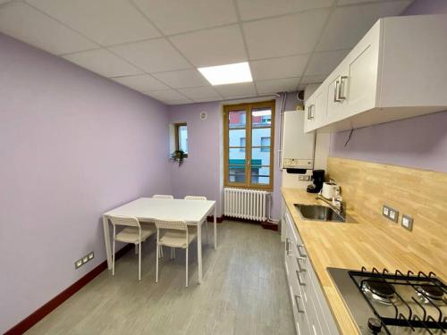 Appartement de 50m2 au centre de Cusset في Cusset: مطبخ مع طاولة وكراسي في غرفة