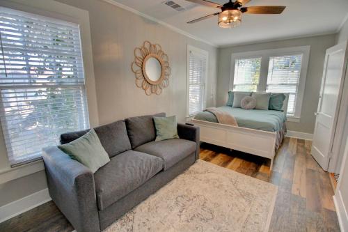 a living room with a couch and a bed at Heart of Galveston Stylish Apt Near Attractions in Galveston