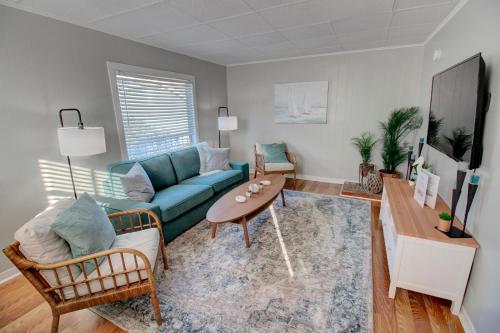 a living room with a blue couch and a table at Heart of Galveston Stylish Apt Near Attractions in Galveston