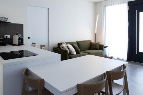 sala de estar con 2 mesas blancas y sofá en RITA apartments, en Bardolino