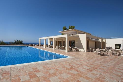 a villa with a swimming pool and a house at Alonissos Beach Bungalows And Suites Hotel in Alonnisos