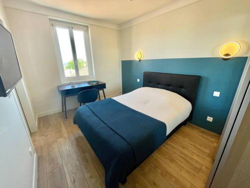 1 dormitorio con cama, escritorio y ventana en Andreossy, en Antibes