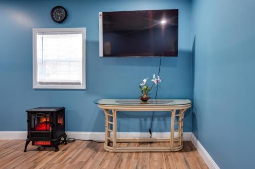 a room with a table with a tv on a blue wall at Saint Helena Island Getaway with Marsh Views! in St. Helena Island