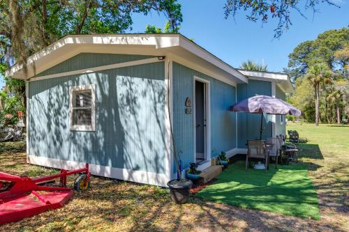 a blue house with a porch and an umbrella at Saint Helena Island Getaway with Marsh Views! in St. Helena Island