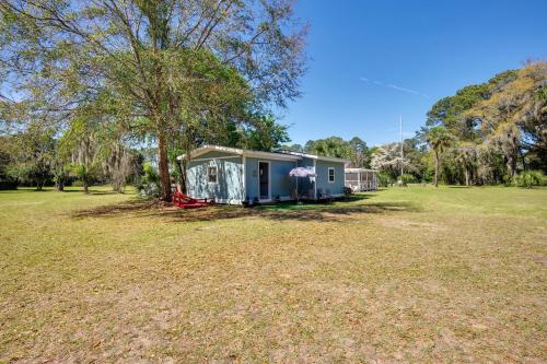 a small house in a field next to a tree at Saint Helena Island Getaway with Marsh Views! in St. Helena Island