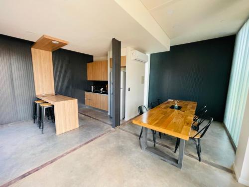 a dining room with a wooden table and chairs at Cubos de Chacras in Ciudad Lujan de Cuyo