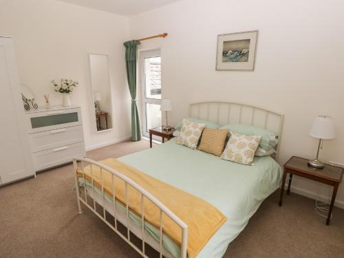 a bedroom with a bed with pillows and a tv at Ty Coets, Morfa Farm in Llantwit Major