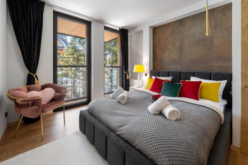 a bedroom with a large bed with colorful pillows at Rezydencja Strążyska & Chalet BBQ in Zakopane