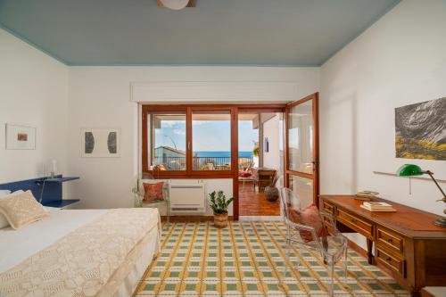 una camera con letto, scrivania e finestra di Villa Arrecifes a Fertilia