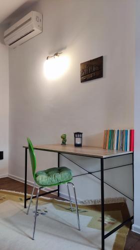 a desk with a green chair in a room at Apartments Protin sokak in Sarajevo