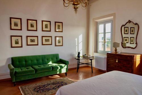 a green couch in a room with a bed at Castellinaria in Lari