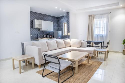 a living room with a couch and tables and a kitchen at Luxury and Modern Apartments in Mudhainib in Al Madinah