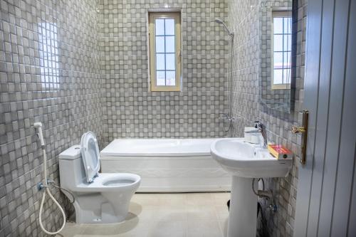 麥地那的住宿－Luxury and Modern Apartments in Mudhainib，浴室配有卫生间、盥洗盆和浴缸。