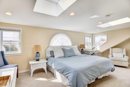 a bedroom with a bed and a chair and windows at Beautiful Common Fence Point Cottage By Beach in Portsmouth