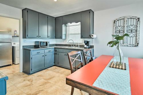 a kitchen with gray cabinets and a red table in it at Charming Cave City Vacation Rental with Fire Pit! in Cave City