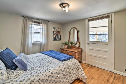 a bedroom with a bed with blue pillows and a mirror at Charming Cave City Vacation Rental with Fire Pit! in Cave City