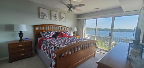a bedroom with a bed and a view of the water at AMAZING LAKE VIEW! GORGEOUS SUNSET! ON MAIN CHANNEL! 3BR/2BA-SLEEPS 6-8 in Lake Ozark