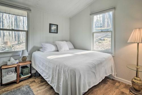 的住宿－Unplugged Mountain Retreat with Porch Swings!，卧室配有白色的床和2扇窗户。