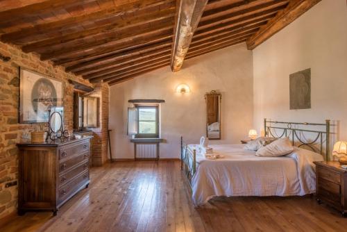a bedroom with a bed and a wooden floor at Casale Rosennano - Padronale in Rosennano