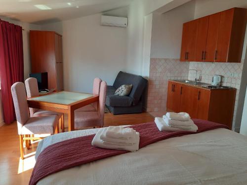 a bedroom with a bed and a table and a kitchen at Residence Gordana in Selce