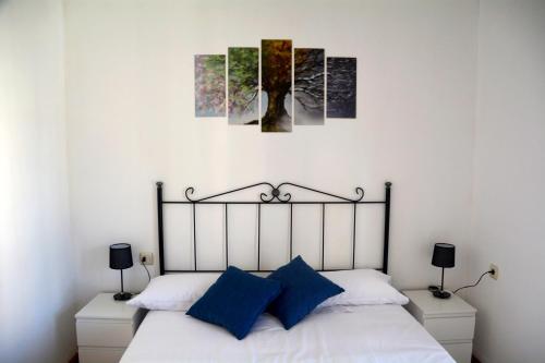 ein Schlafzimmer mit einem Bett mit drei Gemälden an der Wand in der Unterkunft Mirador de los Amantes - VUTE-23-019 in Teruel