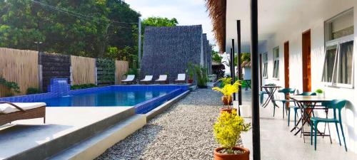 a backyard with a swimming pool and a table and chairs at Sunset Villas Palauig Zambales in Palauig
