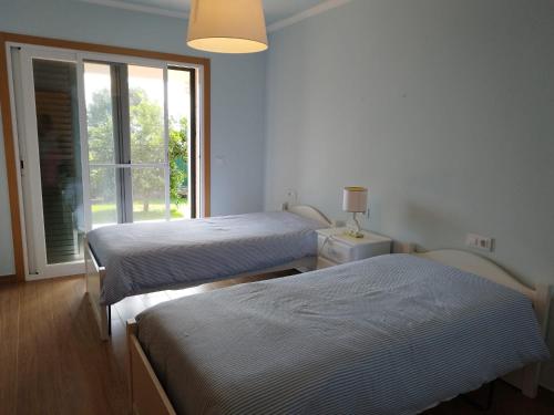 two beds in a room with a window at Casa da Viña in Guillade