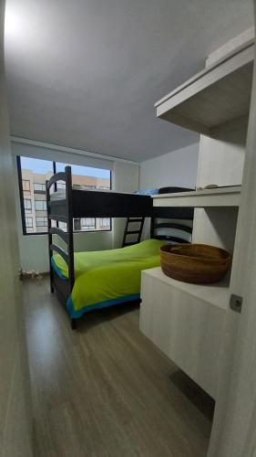 a bedroom with a green bed and a large window at Espectacular Apto Cajicá !Nuevo¡ in Cajicá