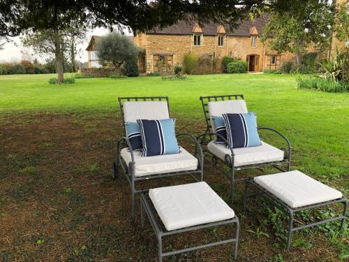 three chairs with blue and white pillows in a yard at Manoir de La Brunie-Grand Longere in Coux-et-Bigaroque
