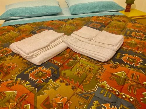 un letto con asciugamani e cuscini sopra di Brevi periodi a Policoro