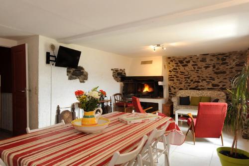 une salle à manger avec une table et une cheminée dans l'établissement Gîte La Source, à Jujols