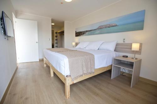 Un dormitorio con una gran cama blanca y una mesa en Urbano Apartments Miraflores Pardo en Lima